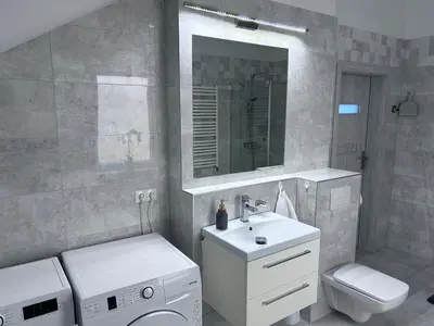 a bathroom with a sink and a toilet and a mirror at AP Apartament in Kraków