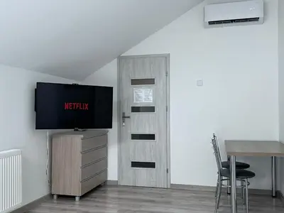 a room with a television and a door with a table at AP Apartament in Kraków
