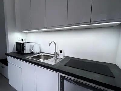 a kitchen with a sink and a microwave at AP Apartament in Kraków