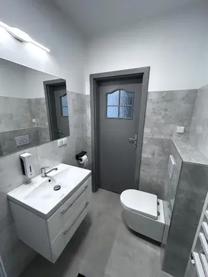 a bathroom with a white sink and a toilet at AP Apartament in Kraków