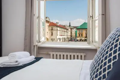a bed with towels on it looking out of a window at Spacious Apartment in Krakow Old Town in Kraków