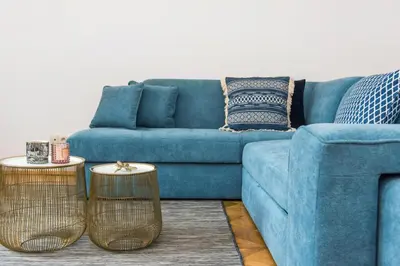 a blue couch with two tables in a living room at Spacious Apartment in Krakow Old Town in Kraków