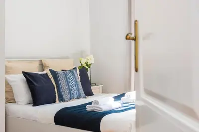 a bedroom with a bed with blue and white pillows at Spacious Apartment in Krakow Old Town in Kraków