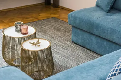 a living room with two tables and a blue couch at Spacious Apartment in Krakow Old Town in Kraków