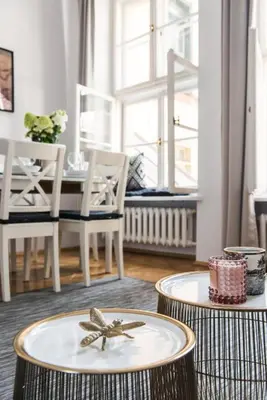 a living room with two stools with a table and chairs at Spacious Apartment in Krakow Old Town in Kraków