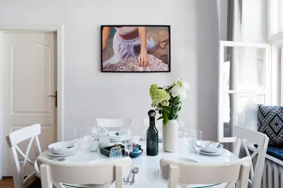 a white dining room with a white table and white chairs at Spacious Apartment in Krakow Old Town in Kraków