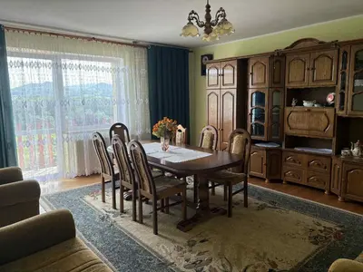 a dining room with a wooden table and chairs at Noclegi w Beskidzie Wyspowym in Przenosza