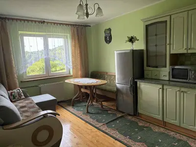 a small kitchen with a table and a refrigerator at Noclegi w Beskidzie Wyspowym in Przenosza