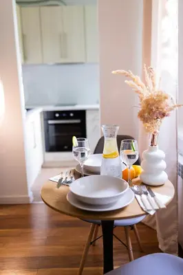 a dining room table with plates and wine glasses at Przytulny Apartament w centrum Rabki in Rabka