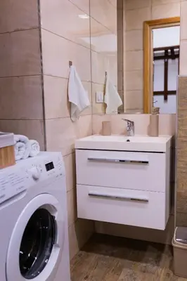 a bathroom with a washing machine and a sink at Przytulny Apartament w centrum Rabki in Rabka
