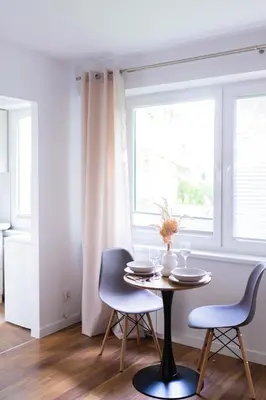 a dining room with a table and chairs and a window at Przytulny Apartament w centrum Rabki in Rabka