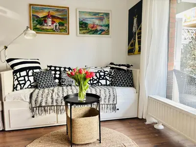 a bedroom with a bed with a table and a window at Bronowice Art Garden - Cozy Apartment with Garden and Parking in Kraków