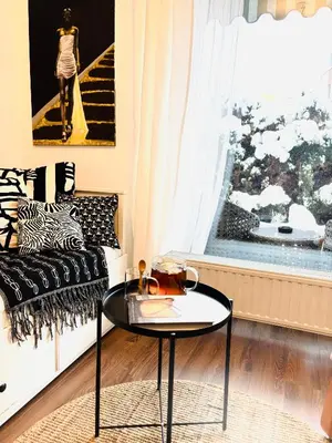 a living room with a couch with pillows and a table at Bronowice Art Garden - Cozy Apartment with Garden and Parking in Kraków