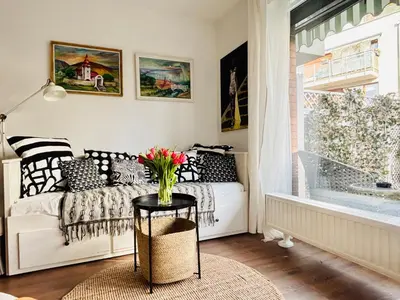 a living room with a chair and a table at Bronowice Art Garden - Cozy Apartment with Garden and Parking in Kraków