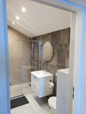 a bathroom with a toilet and a sink and a shower at Panorama Resort in Radocza