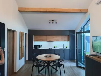 a kitchen and dining room with a table and chairs at Panorama Resort in Radocza