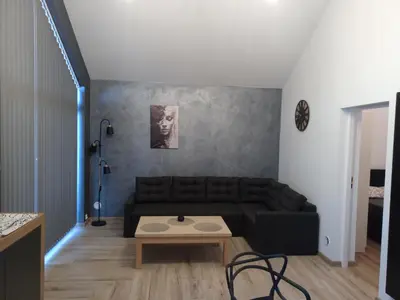 a living room with a black couch and a table at Panorama Resort in Radocza