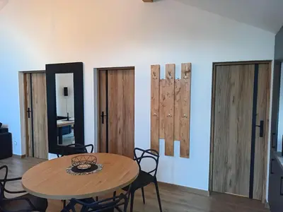 a dining room with a table and some wooden doors at Panorama Resort in Radocza