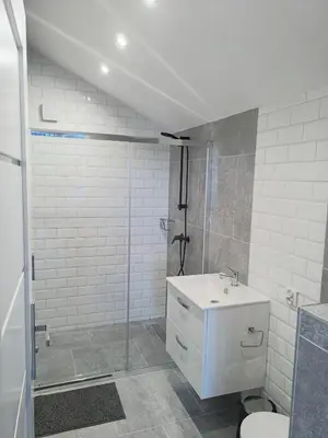 a white bathroom with a sink and a shower at Panorama Resort in Radocza