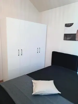 a bedroom with a bed with white cabinets and a pillow at Panorama Resort in Radocza