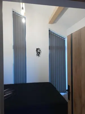 a bedroom with a black bed and a window at Panorama Resort in Radocza