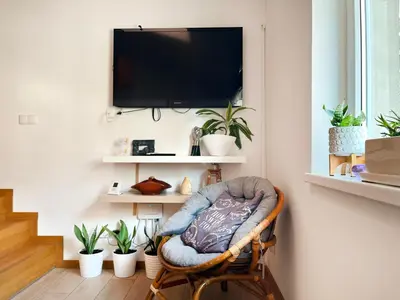 a room with a chair with a television on a wall at Modern Apartments with Air Conditioning, Vistula Boulevards, Cracow city heart in Kraków