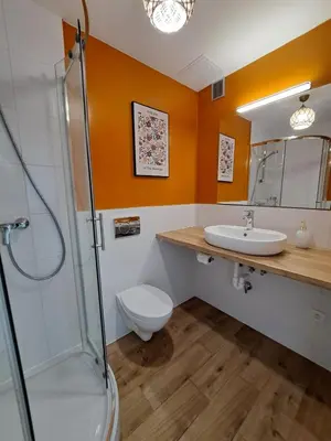 a bedroom with a bed and a chair and a window at RentApart in Kraków