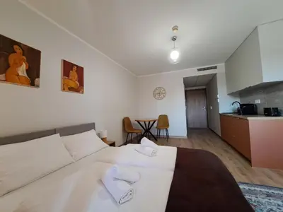 a bedroom with a large bed and a kitchen at RentApart in Kraków