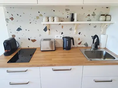 a kitchen counter with a sink and a wall with hearts at RentApart in Kraków