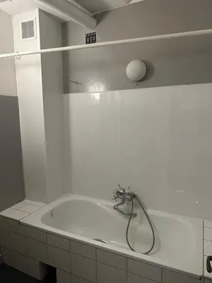 a bathroom with a bath tub with a shower at City Center Rooms in Kraków