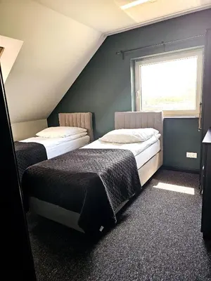 two beds in a room with a window at Willa za Zeliną