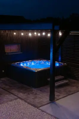 a hot tub with lights on the side of a building at Willa za Zeliną