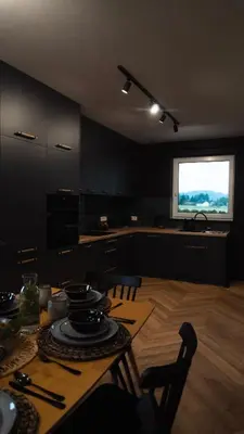 a kitchen with a table with chairs and a window at Willa za Zeliną