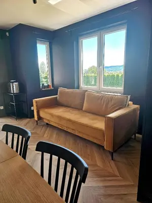 a living room with a couch and two windows at Willa za Zeliną