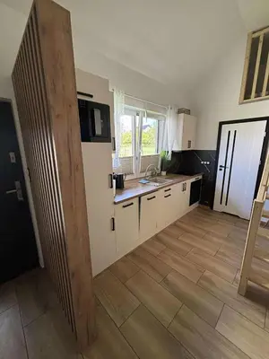 a kitchen with white cabinets and a wooden floor at Domek u Oli - blisko Energylandia, Wadowice, Kraków, Oświęcim in Bachowice