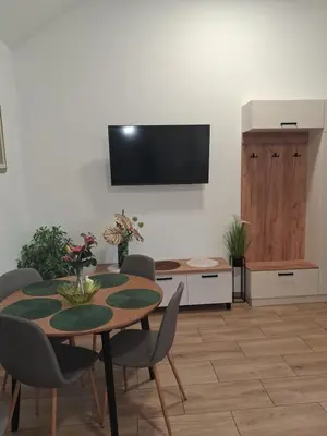 a dining room with a table and a tv on a wall at Domek u Oli - blisko Energylandia, Wadowice, Kraków, Oświęcim in Bachowice