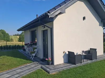 a house with two chairs and a patio at Domek u Oli - blisko Energylandia, Wadowice, Kraków, Oświęcim in Bachowice
