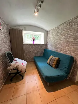a room with a blue couch and a chair at Kawalerka-Studio underground in Kraków