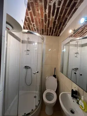 a bathroom with a shower and a toilet and a sink at Kawalerka-Studio underground in Kraków
