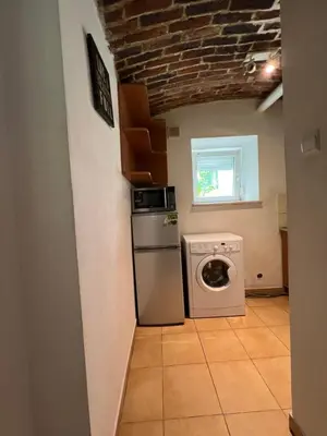 a kitchen with a washer and dryer in a room at Kawalerka-Studio underground in Kraków