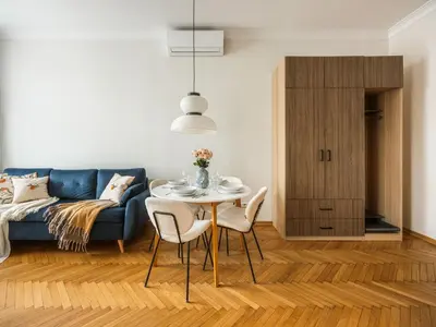 a living room with a blue couch and a table and chairs at Fragola Apartments Florian Gate in Kraków