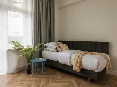 a bedroom with a bed and a table and a window at Fragola Apartments Florian Gate in Kraków