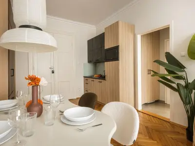 a dining room with a white table and chairs at Fragola Apartments Florian Gate in Kraków