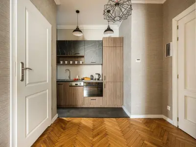 a kitchen with wood floors and a door and a kitchen at Fragola Apartments Florian Gate in Kraków