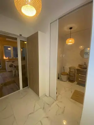 a living room with white marble floors and a kitchen at Solne Apartamenty Luna 4 in Wieliczka