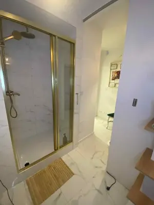a bathroom with a shower with a glass door at Solne Apartamenty Luna 4 in Wieliczka