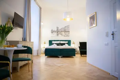 a bedroom with a bed and a table and chairs at Apartments Roman in Kraków