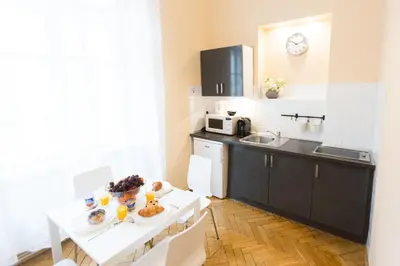 a kitchen with a sink and a table with food on it at Apartments Roman in Kraków