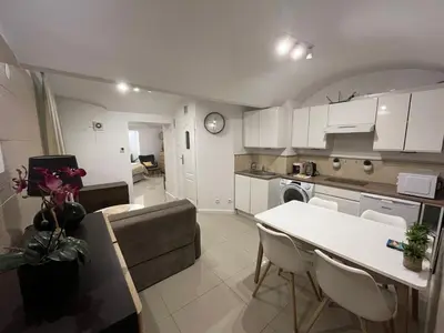 a kitchen and living room with a table and a couch at A&J Apartments in Kraków