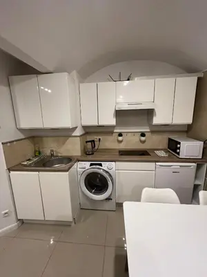 a white kitchen with a sink and a washing machine at A&J Apartments in Kraków